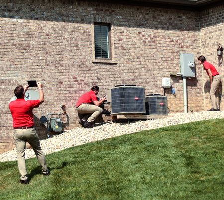 Three HomeTeam inspectors inspecting the exterior of a home
